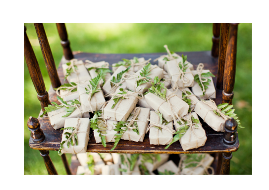 Petits paquets décorés de verdure, disposés sur une chaise en bois.